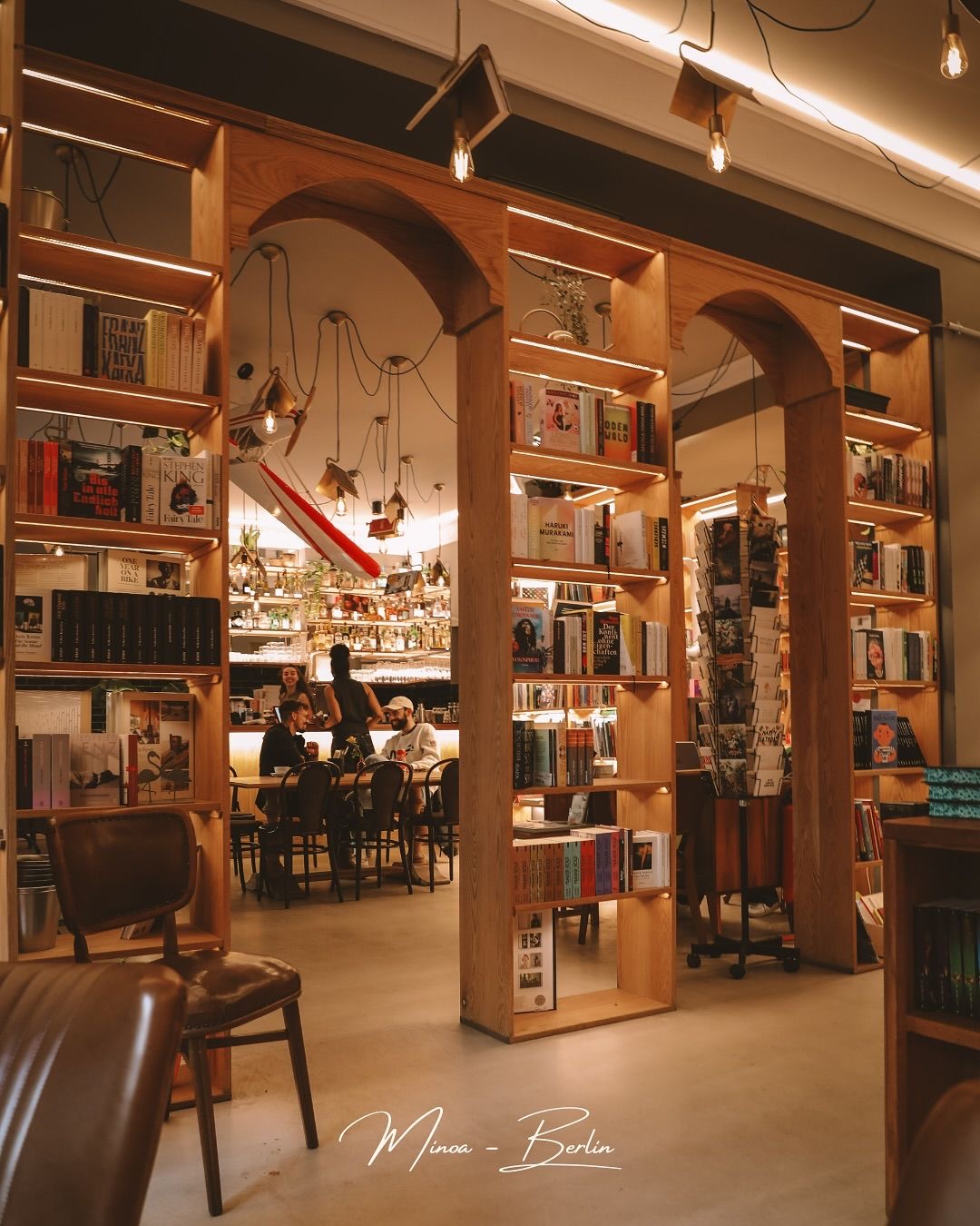 Floor-to-ceiling bookshelves with warm Edison bulb lighting